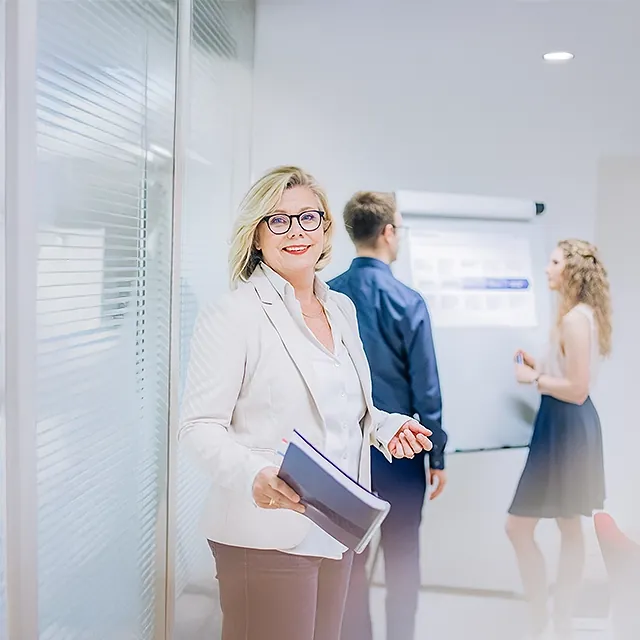 Britta Veser unterstützt Jan-Michael Bussmann und Sophie Buchta bei der Aufbereitung von Workshopergebnissen am Flipchart.