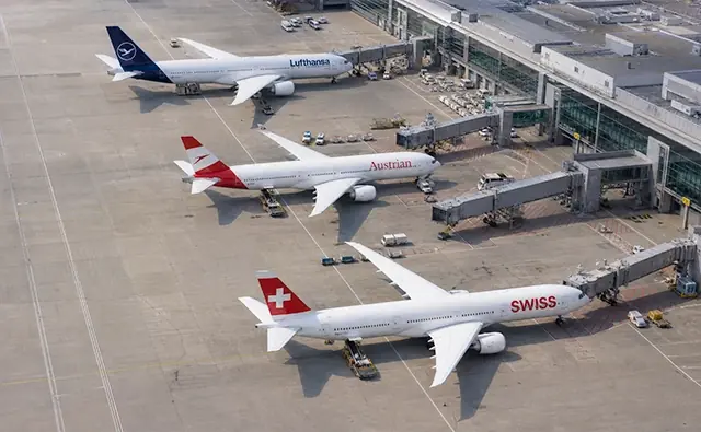 Flugzeuge der verschiedenen Airlines der Lufthansa Gruppe mit sichtbaren Heckflossen auf dem Rollfeld.