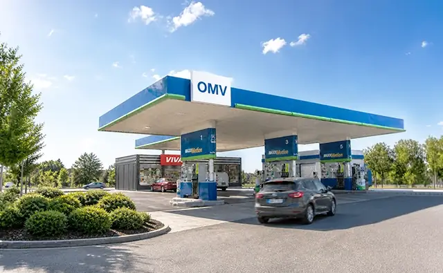 OMV-Tankstelle mit VIVA-Shop bei Sonnenuntergang.