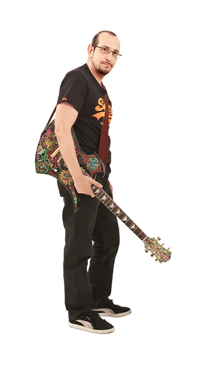 Mag. Bernhard Steger trägt ein schwarzes T-Shirt und hält eine auffällig verzierte E-Gitarre – seine Leidenschaft für Musik ist unübersehbar.