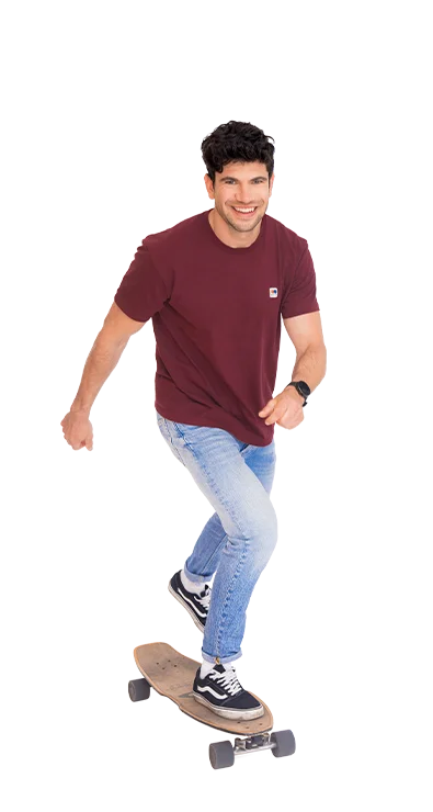 Christoph Halbertschlager, MA fährt schwungvoll auf einem Longboard, lächelt und trägt sportlich-leger Jeans und Shirt – voller Dynamik und Spaß an Bewegung.