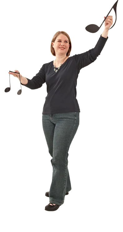 Mag. Irene Löffler bewegt sich schwungvoll mit erhobenen Armen, als würde sie dirigieren – mit musikalischem Ausdruck und spürbarer Leidenschaft für Rhythmus und Melodie.