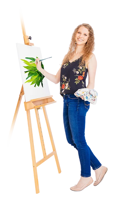 Sophie Buchta, MSc (WU) steht vor einer Staffelei und malt grüne Pflanzen auf eine Leinwand, das Tuch in der Hand – naturverbunden, fröhlich und voller Kreativität.