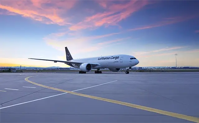 Frachtflugzeug der Lufthansa Cargo auf einem Rollfeld bei Sonnenuntergang. Bild steht für globale Logistiklösungen und den effizienten Gütertransport per Luftfracht.
