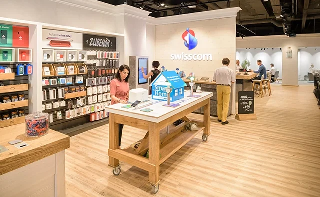 Modernes Kundenservice-Center von Swisscom mit minimalistischer Inneneinrichtung und Markenlogo. Bild steht für Digitalisierung, Beratungskompetenz und Kundennähe.