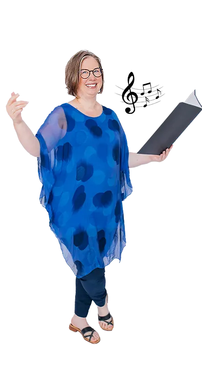 Mag. Irene Löffler mit offenem Notenordner und erhobener Hand in Dirigier-Pose - musikalisch, ausdrucksstark und voller Freude am Klang.