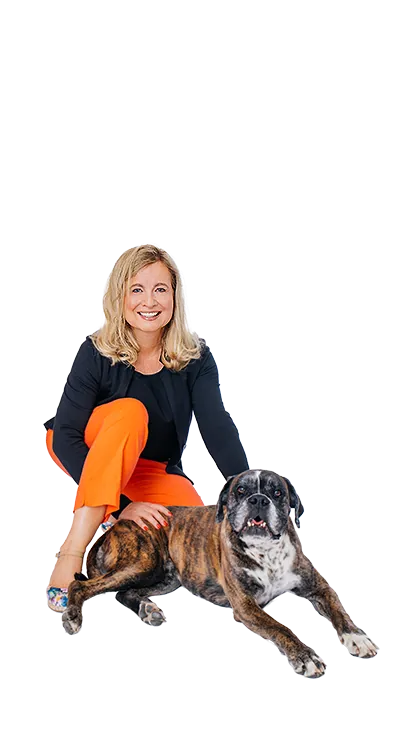 Dipl.-Kff. Dr. Verena Priemer kniet lächelnd neben einem braunen Hund, legt ihm die Hand auf den Rücken und strahlt Ruhe und Verbundenheit aus - tierlieb, herzlich und voller positiver Energie.